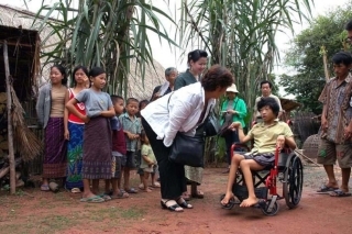 ຖ່າຍກັບນ້ອງທີ່ນັ່ງລໍ້ເລື່ອນແລະ ປະທານ(ການສໍາຫຼວດສະພາບຂອງຄົນພິການປີ2001). ພວກເຮົາໄດ້ບໍລິຈາກລໍ້ເລື່ອນໄປທີ່ໝູ່ບ້ານ ທີ່ຫ່າງຈາກນະຄອນຫຼວງວຽງຈັນ 50 ກິໂລແມັດ ແລະ ໄດ້ມອບລໍ້ເລື່ອນໃຫ້ເດັກຍິງທີ່ບໍ່ສາມາດຍ່າງດ້ວຍຂາຂອງຕົວເອງຍ້ອນພະຍາດທາງສະໝອງ. 車いすの少女と会長(障害者事情調査2001年)